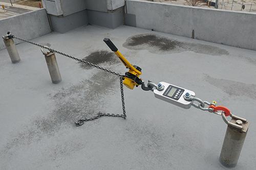 Roof anchor load testing using calibrated dynamometer on industrial rooftop in Ontario